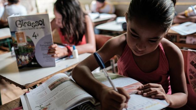 Niñas escriben en pupitres en una escuela en Brasil