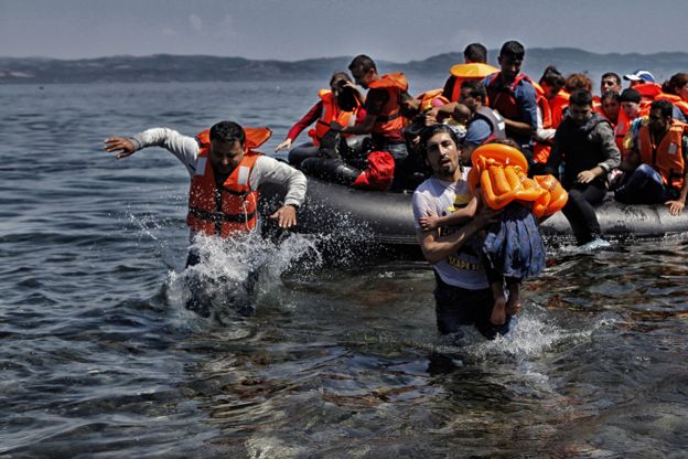 The refugees wade ashore