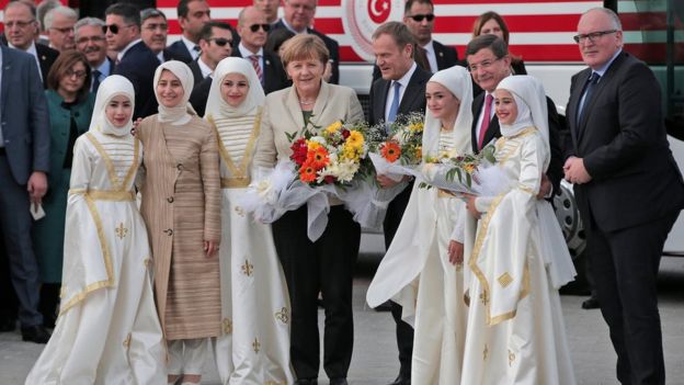 German Chancellor Angela Merkel, centre, accompanied by EU Council President Donald Tusk, centre right, Turkish Prime Minister Ahmet Davutoglu, 2nd right, and EU Commission Vice President Frans Timmermans, right, pose for pictures during a visit at the Nizip refugee camp in Gaziantep province.