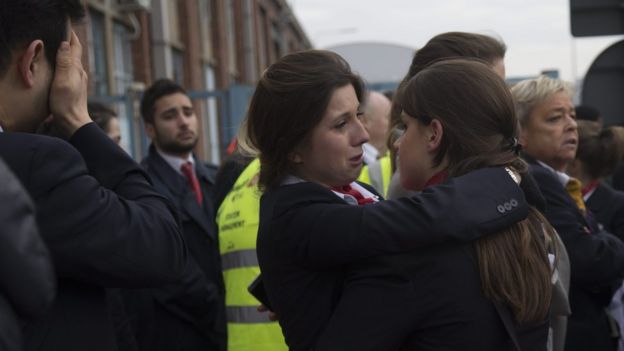 Airport staff comfort each other following attacks