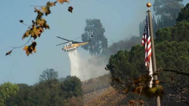 A helicopter drops water on a vineyard owned by Rupert Murdoch damaged by the Skirball fire near the Bel Air neighbourhood on the west side of Los Angeles