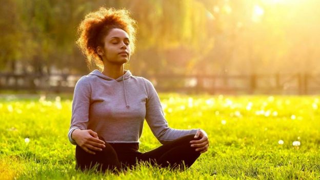 Una persona meditando en un parque
