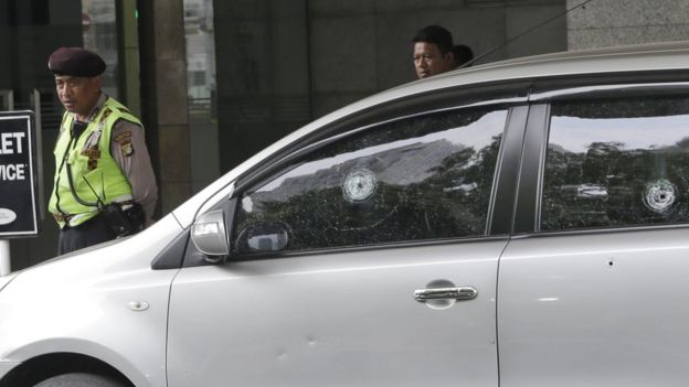 Bullet holes in the window of a car outside the Starbucks cafe targeted in Jakarta, 15 January