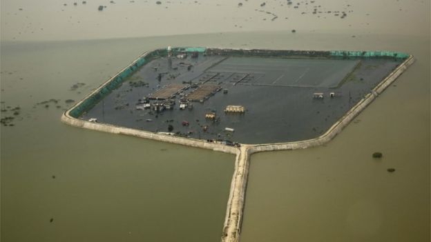 A factory and a residential area are seen marooned in the river Ganges flood waters on the outskirts of Allahabad, India, Friday, Aug. 26, 2016.