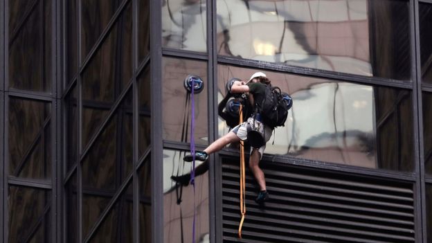 A man scales the all-glass facade of Trump Tower, Wednesday
