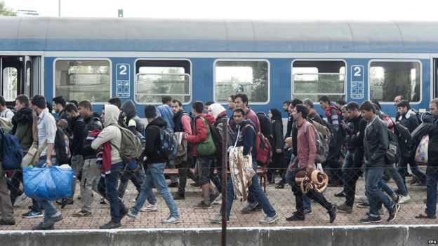 Migrants walk at a Hungarian train station