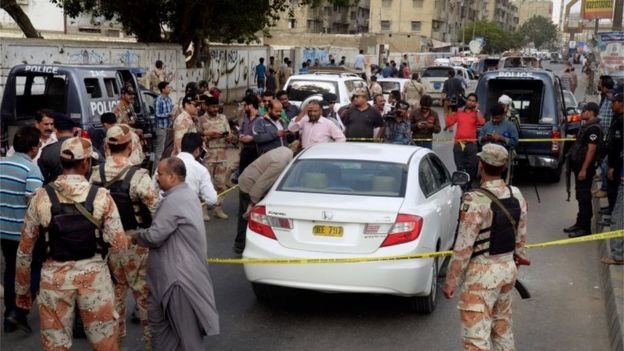 Pakistani investigators and journalists gather around the blood-stained car of famous Sufi singer Amjad Sabri after an attack in Karachi, Pakistan, Wednesday, June 22, 2016.