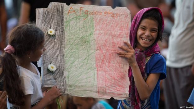 A young girl holds up a handmade flag of Afghanistan as migrants protest outside Keleti station in central Budapest after it was closed to migrants earlier today on September 1, 2015 in Budapest, Hungary.