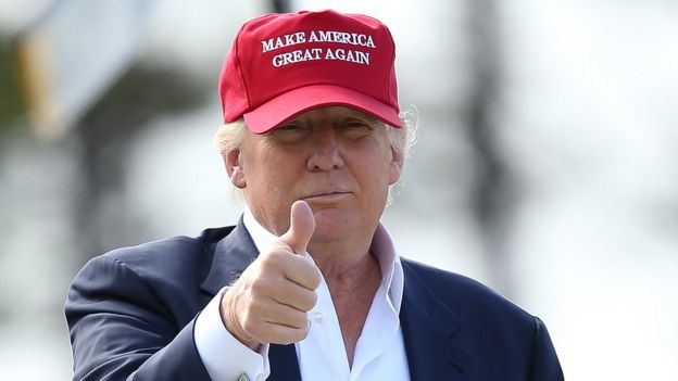 Donald Trump usa boné com mote da campanha e faz sinal de positivo em visita à Escócia em 2015