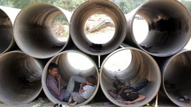 Indians rest in unused water pipes to avoid the heat on a hot summer day in New Delhi, India, 19 May 2016
