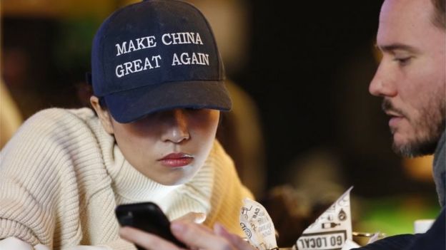 A woman wears a cap with a China message that is reminiscent of the campaign slogan of US President-elect Donald Trump 