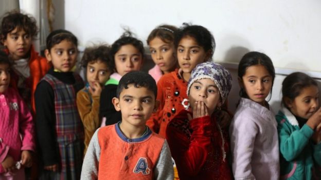 Iraqi children line up at a camp for displaced people, in the al-Shurta neighbourhood of west Baghdad, 14 Dec 2015