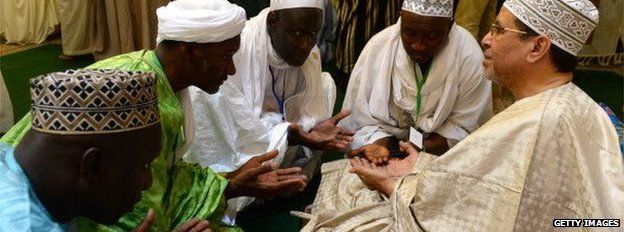Members of the Tijaniyya Brotherhood receive blessing from a descendant (R) of Sheikh Sidi Ahmed al-Tijani who lived during the eighteenth century as they take part in a remembrance for him on May 14, 2014 in the Moroccan city of Fes.