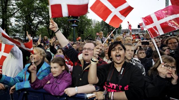 Personas con banderas de Dinamarca.