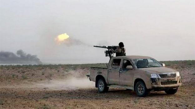 An Islamic State fighter fires his weapon during a battle against Syrian government forces on a road between Homs and Palmyra, Syria, on 21 May 2015
