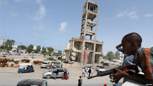 A boy holds his toy gun near former Somali parliament during the celebration after attending Eid al-Fitr prayers to mark the end of the fasting month of Ramadan in Somalia's capital Mogadishu, 17 July 2015