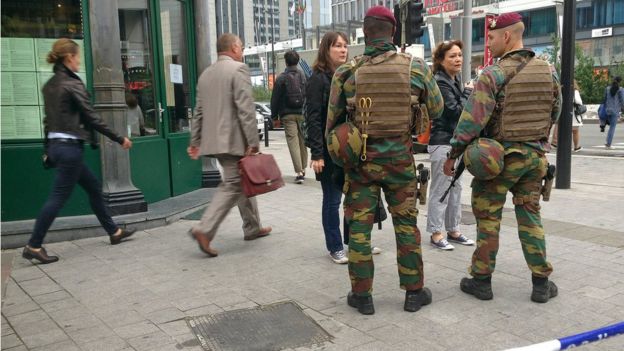 Belgian soldiers speak to people near a blocked off area in downtown Brussels Tuesday June 21, 2016 after Belgian authorities took a man into custody following a pre-dawn security alert at a major shopping center