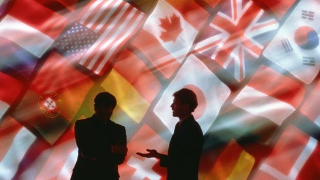 Businessmen talking in front of flags
