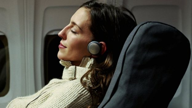 mujer escuchando música en avión