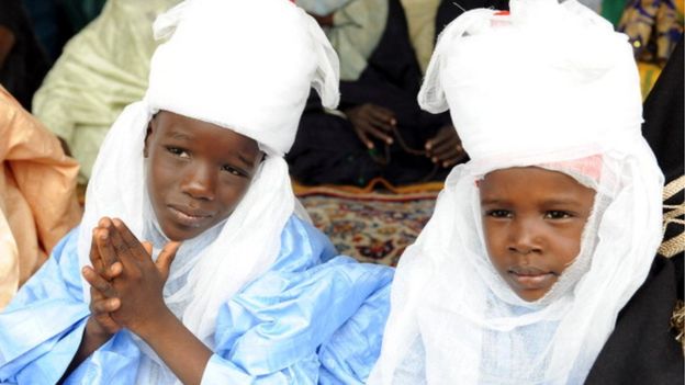 Children of the head of the Fulani indigenes in Lagos, Sadiq (L) and Prince Hamza Bambado pray with Muslim faithfuls on the first day of Eid al-Fitr at Obalende praying ground in Lagos on August 19, 2012.