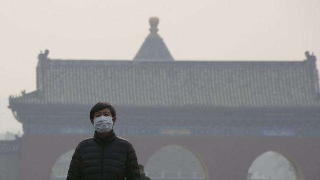 A visitor wearing a protective mask walks at the Temple of Heaven park as China