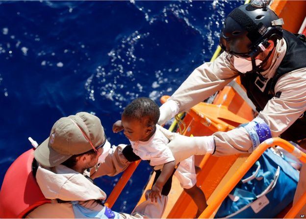 A baby is helped to board on the Norwegian Siem Pilot ship during a migrant search and rescue mission off the Libyan Coasts, Tuesday, Sept. 1, 2015.