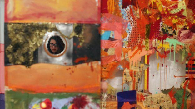 A woman is reflected in a piece of work entitled Minutiae by Robert Rauschenberg