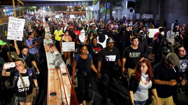 Protestors defied a curfew on Thursday night to protest against the shooting of Mr Scott