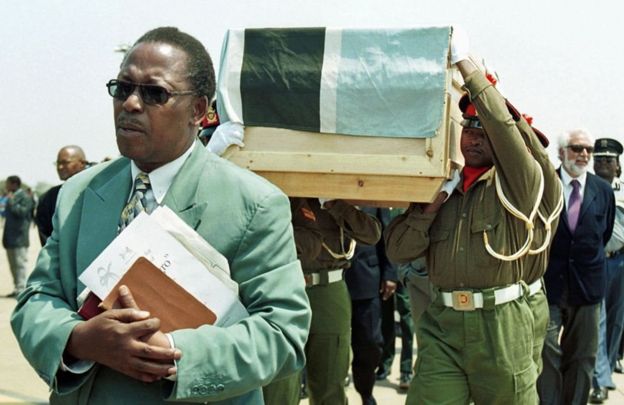Líderes religiosos acompanham o caixão de El Negro, carregado por soldados de Botswana
