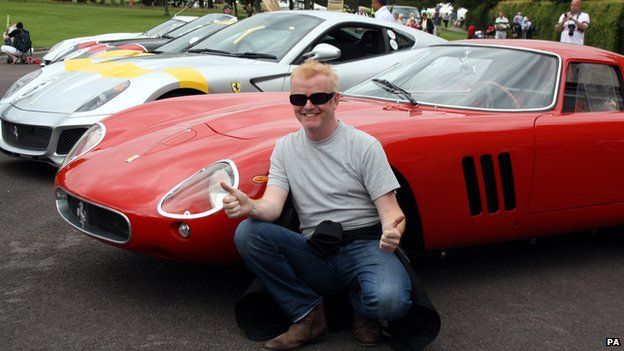Chris Evans posing in front of classic Ferraris