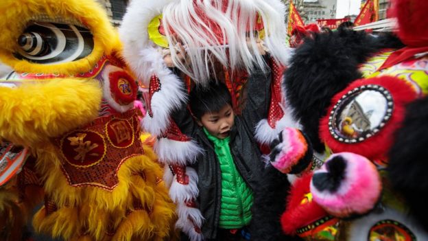 A young performer prepares to take part in a Chinese New Year parade