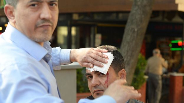 A man gives first aid to an injured man following a bombing, in Bursa, northwestern Turkey, on April 27, 2016
