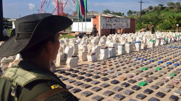 Colombian police officer guards confiscated packages of cocaine in Turbo, Colombia, 15 May 2016