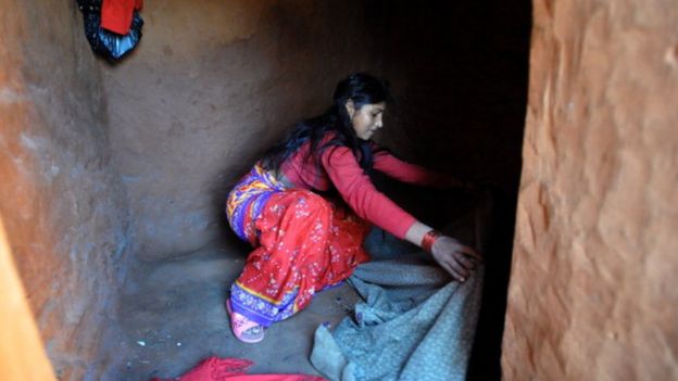A teenaged girl in Nepal prepares her bedding inside a 'chhaupadi house' in the village of Achham, some 800km west of Kathmandu (23 November 2011)