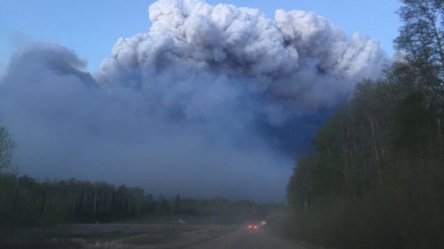 Smoke billows up above a road in Fort McMurray, 5 May 2016