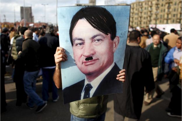 A man carries a picture depicting Egyptian President Hosni Mubarak as Adolf Hitler during a protest in Cairo on 31 January 2011