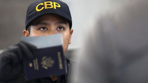 Un funcionario de Migración verifica un pasaporte en un aeropuerto de Estados Unidos.