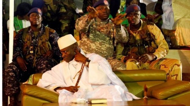 Gambia's President Yahya Jammeh sits on a sofa surrounded by military men at a rally in Banjul, Gambia on 29 November 2016