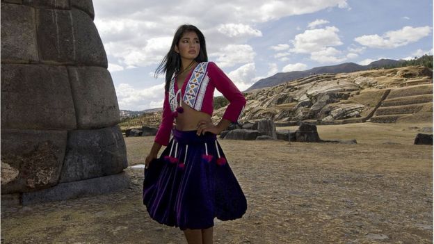 Modelo de rasgos andinos luce vestimenta tradicional pero modernizada frente a ruinas incas
