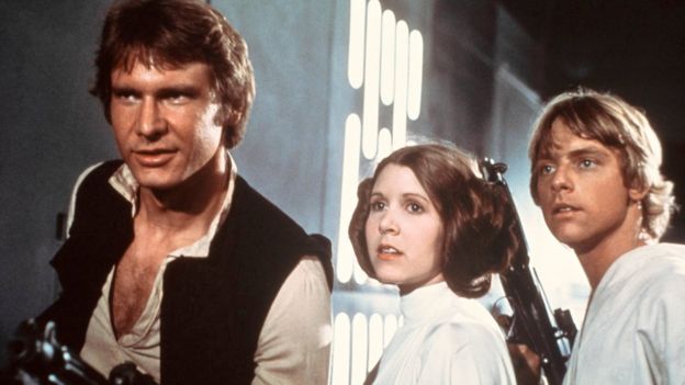 From left to right: Harrison Ford, Carrie Fisher, and Mark Hamill are shown in a scene from Star Wars