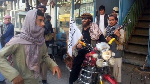 In this Tuesday, Sept. 29, 2015 file photo, a Taliban fighter sits on his motorcycle adorned with a Taliban flag in a street in Kunduz, Afghanistan.