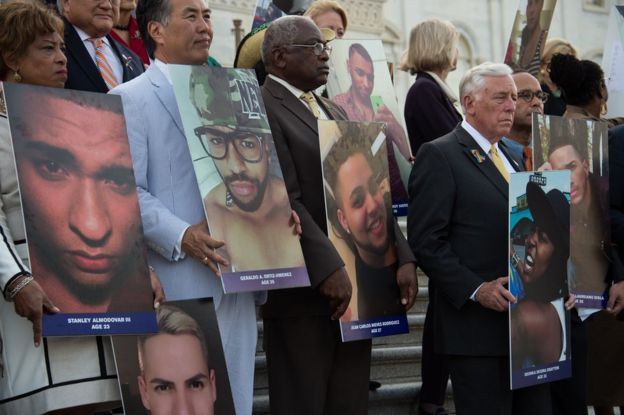 Members and supporters of the US Congressional LGBT Equality Caucus hold pictures of victims of the Pulse nightclub attack in Orlando, on the East House steps of the US Capitol in Washington, DC, 12 July