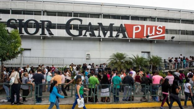People queue outside a supermarket in Caracas (13 January)