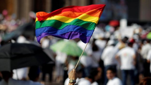 Un hombre sostiene una bandera de la comunidad LGBT en Monterrey, durante las marchas en contra del matrimonio gay.