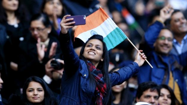 A woman takes a 'selfie' on her phone among the crowd at Wembley Stadium