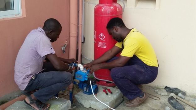 Nigerian businessman Anselm Okoukoni (R) at work
