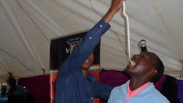 Penuel Mnguni putting a snake in the mouth of a worshipper