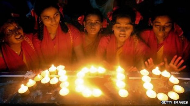 Young Bangladeshi acid attack victims use candles to write the word