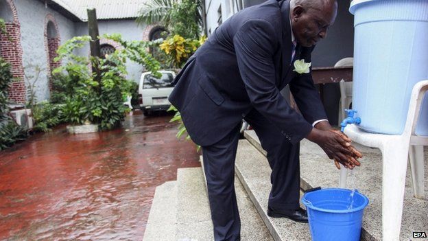 A Liberian man washes his hands as an extra precaution for the prevention of the spread of the Ebola virus before entering a church service in Monrovia, Liberia -27 July 2014