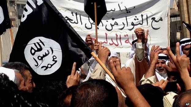 Islamic State supporters attend a rally outside the Nineveh provincial government headquarters in Mosul (16 June 2014)